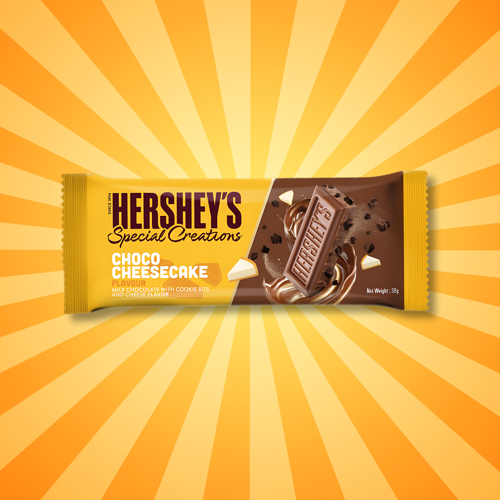 Hershey’s Choco Cheesecake bar on a yellow sunburst background with cookie bits and chocolate swirls.