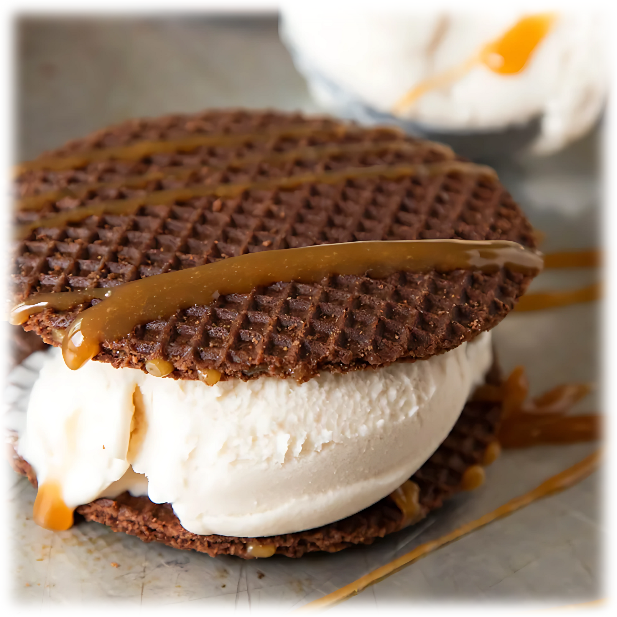 Vanilla ice cream sandwiched between two chocolate stroopwafel cookies, drizzled with caramel sauce.