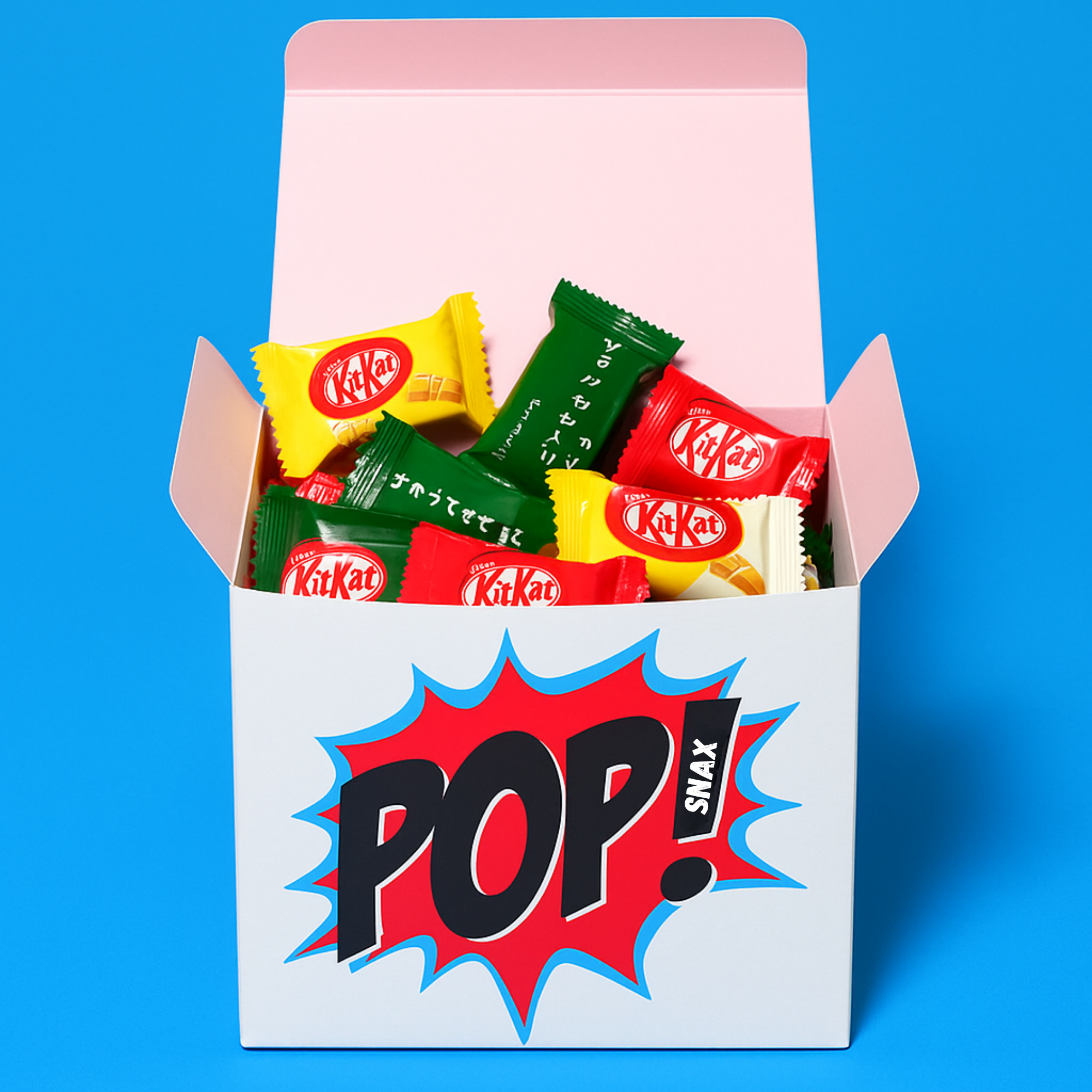 Front-facing product photo of the Pop Snax Tokyo Fun Box filled with Japanese KitKats in red, yellow, and green wrappers, set against a solid blye background background.