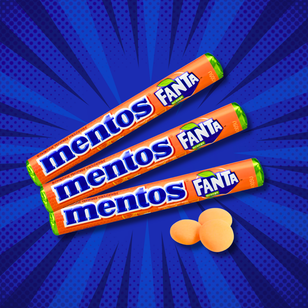 Three Mentos Fanta Orange rolls with orange candies on a blue graphic background
