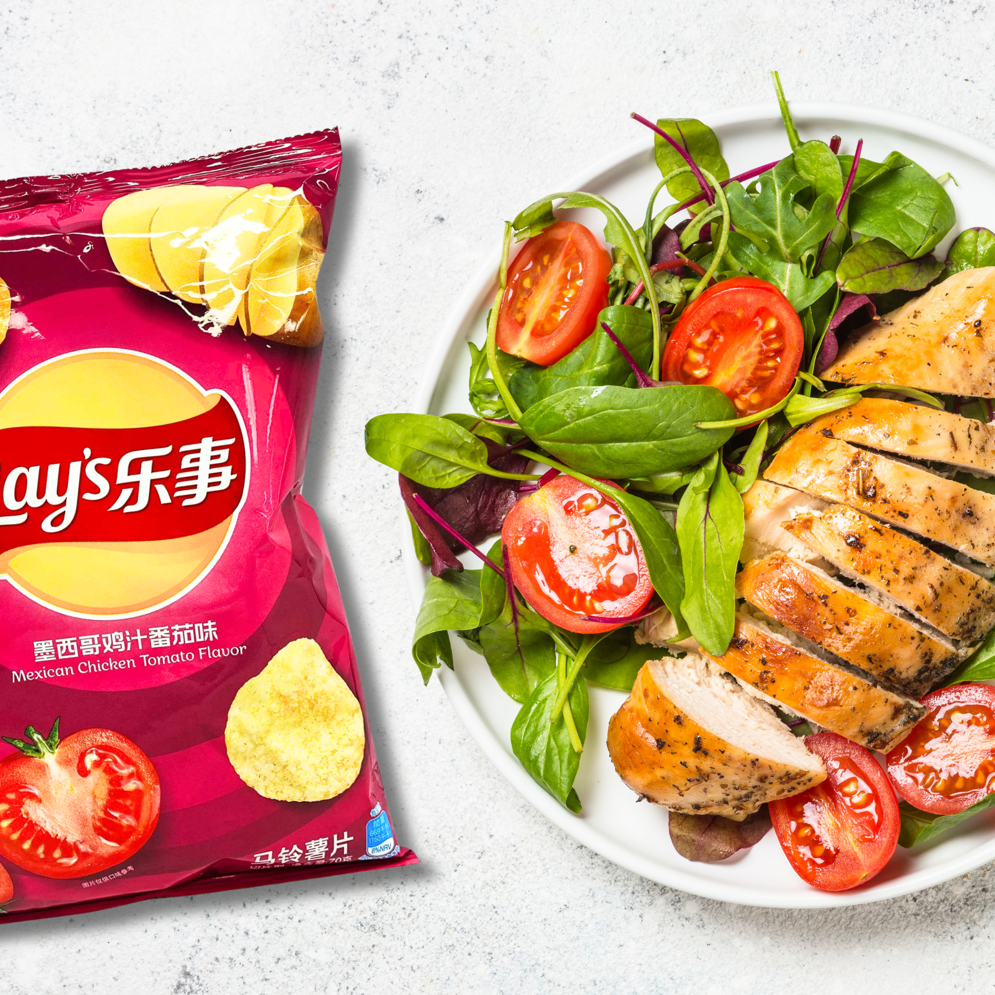 A Mexican Chicken Tomato flavored Lay’s chip bag is next to a white plate with sliced grilled chicken, fresh spinach, and cherry tomatoes.