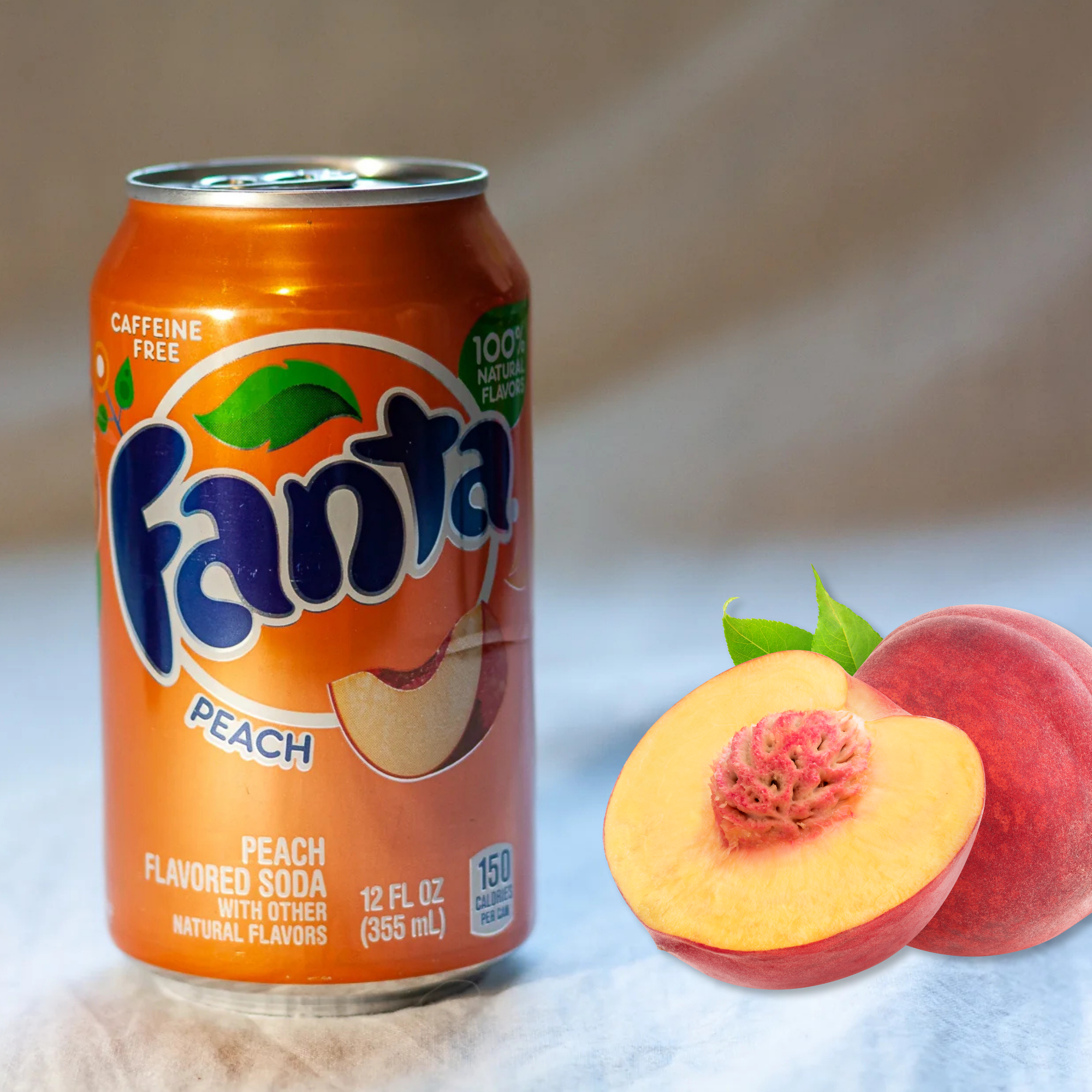 Peach Fanta soda can beside two whole and one halved peach, highlighting its fruity ingredients.