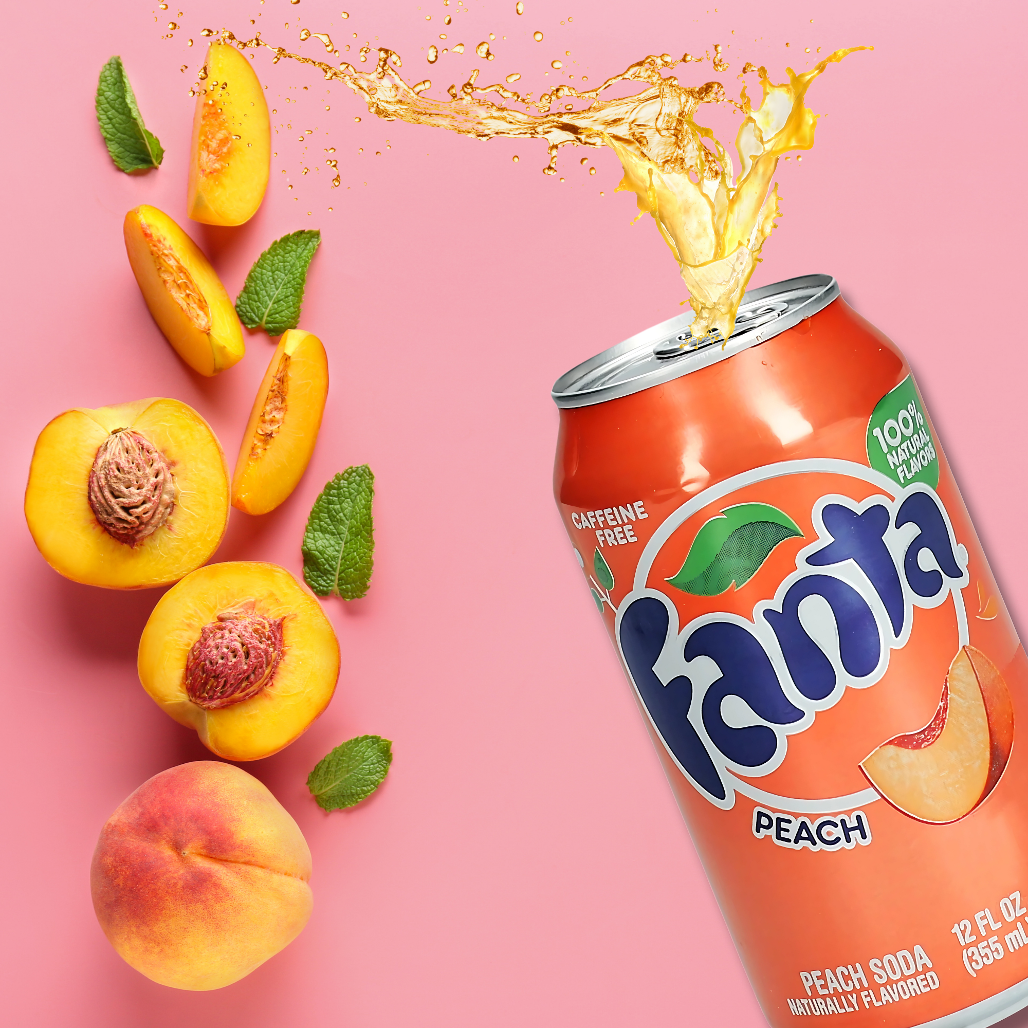 Splashing Peach Fanta can with fresh peaches on a pink background.