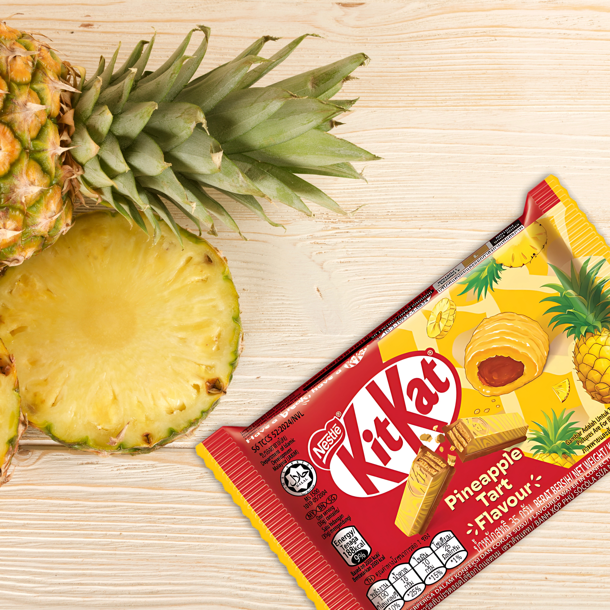 KitKat Pineapple Tart bar next to fresh pineapple slices on a wood surface