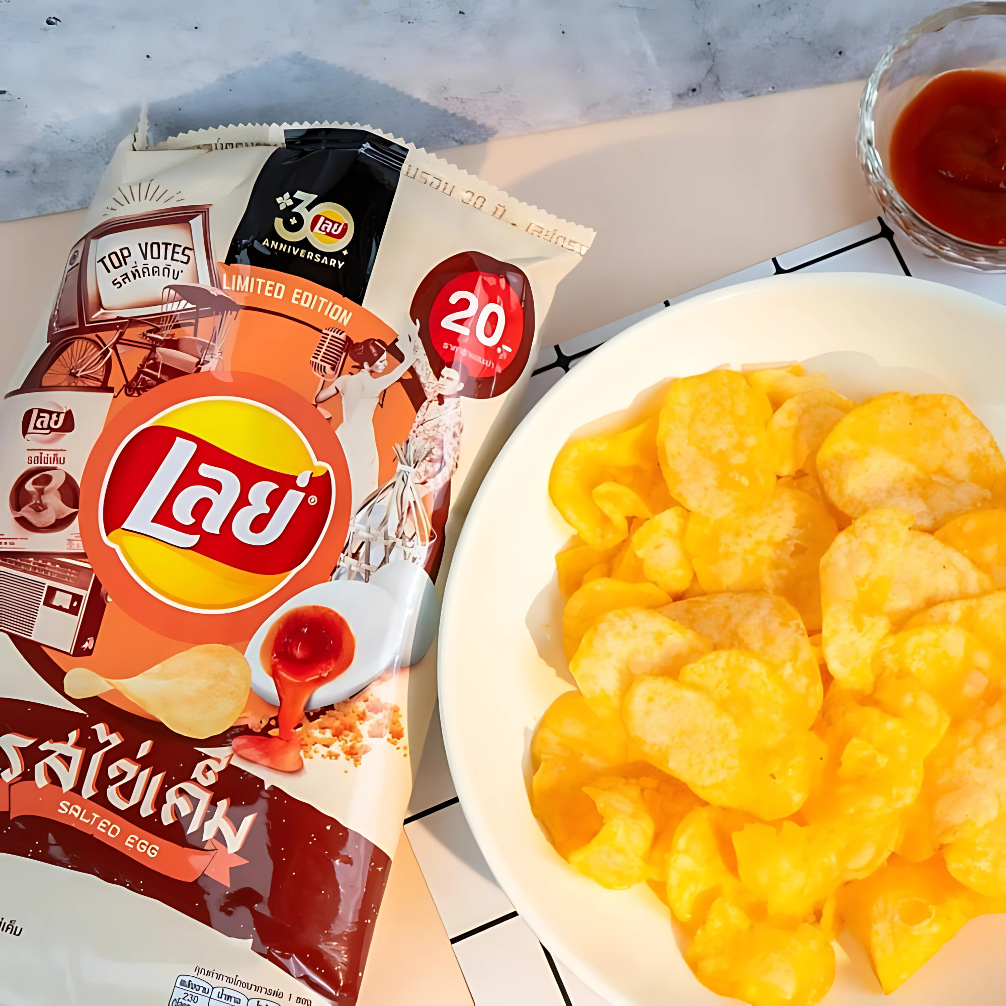 Salted Egg Lay’s Chips served beside the bag – bright orange egg yolk-coated crisps with sweet chili dip on the side