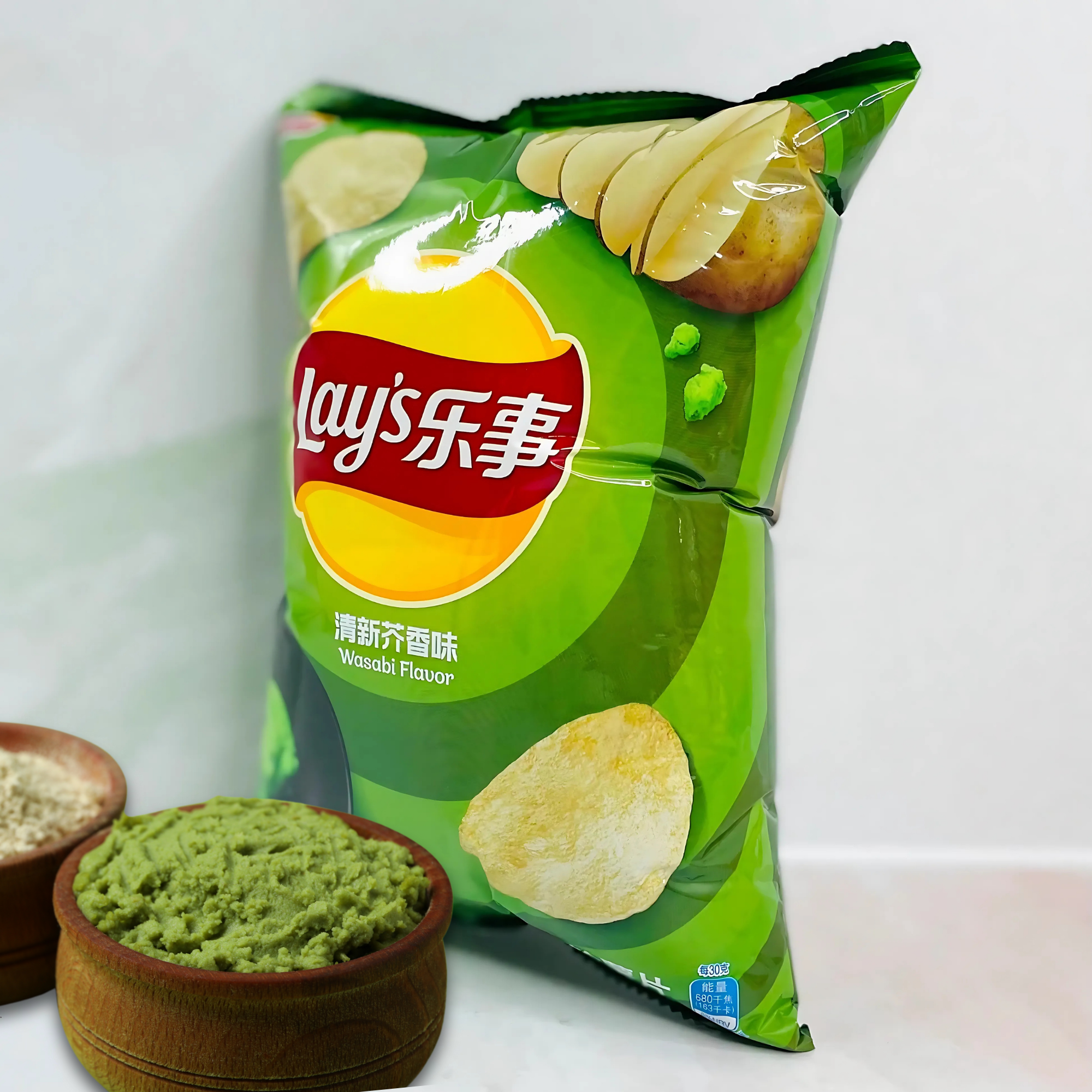 Side view of Lay’s Wasabi potato chips bag with real wasabi and salt ingredients shown in wooden bowls.