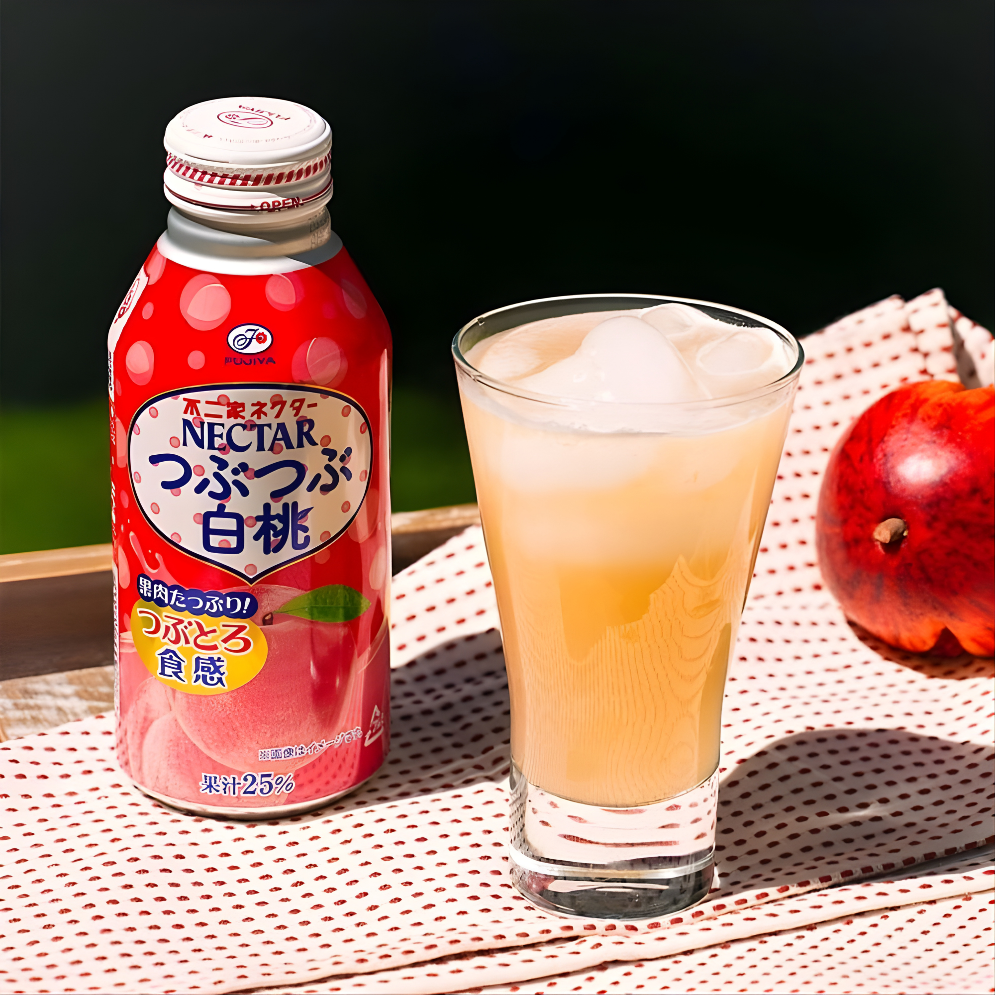 A bottle of Fujiya Peach Nectar Juice from Japan sits next to a glass filled with ice and the drink. A fresh peach and a dotted cloth are in the background.