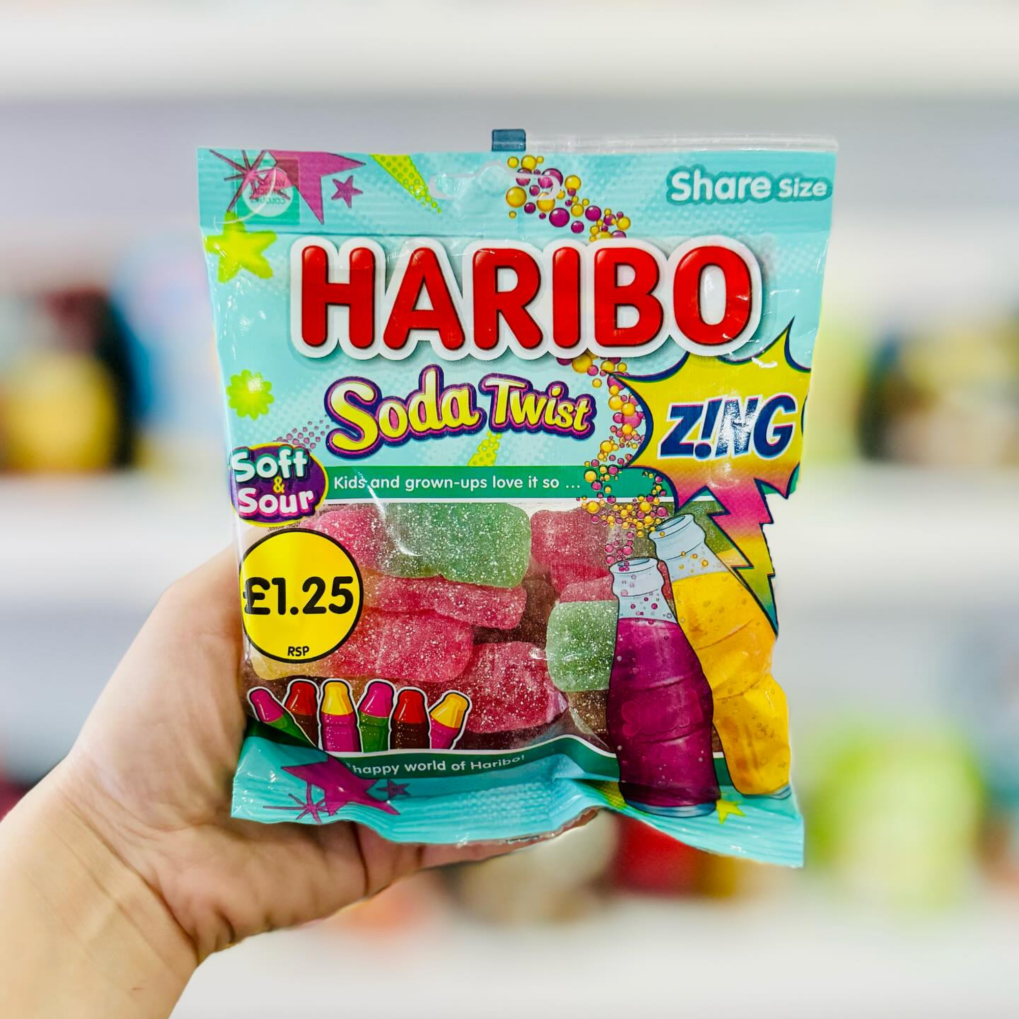 A hand holding a pack of Haribo Soda Twist Zing from the UK. Shop UK candy online.