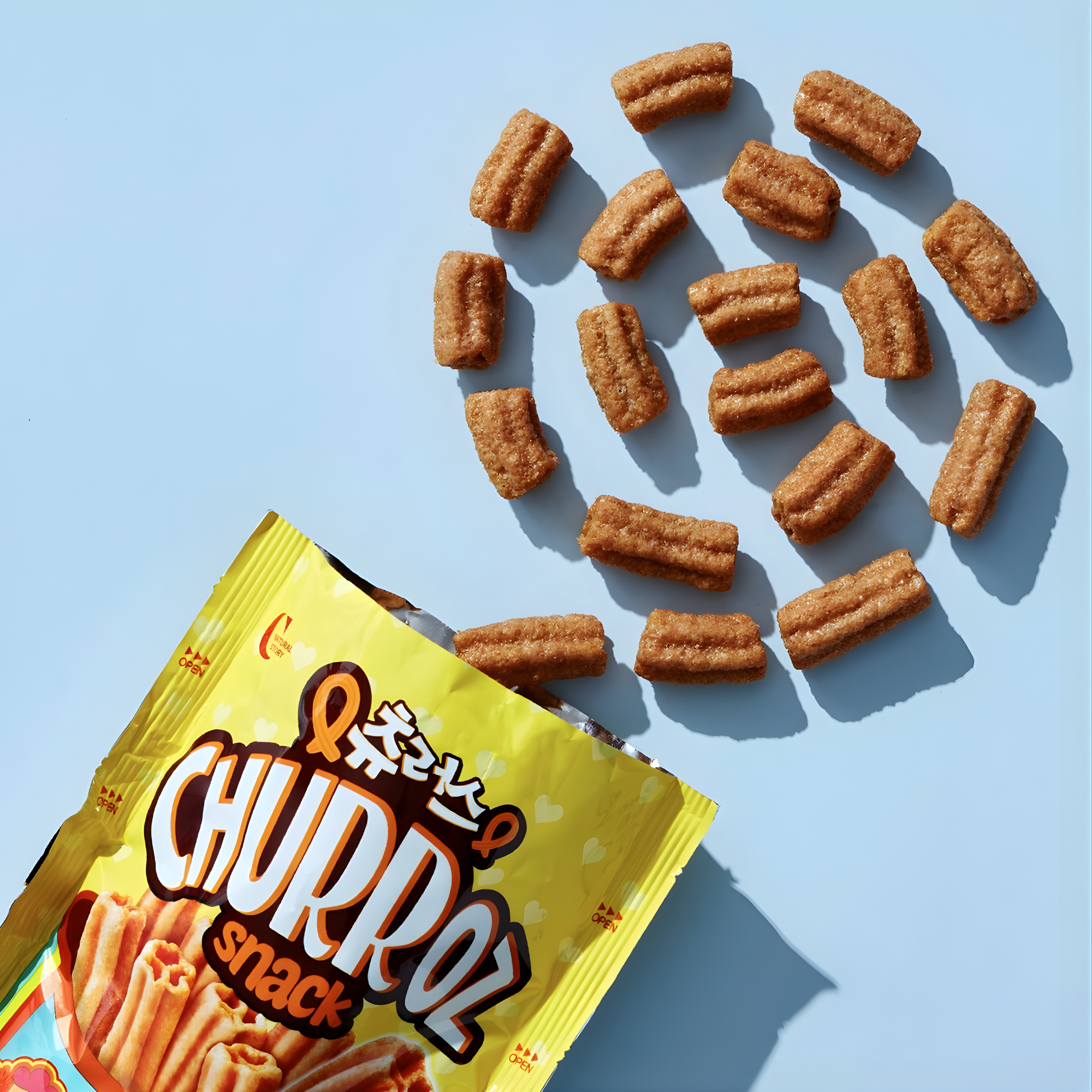 Korean Churroz snack sticks arranged in swirl with cinnamon sugar churro pieces and packaging
