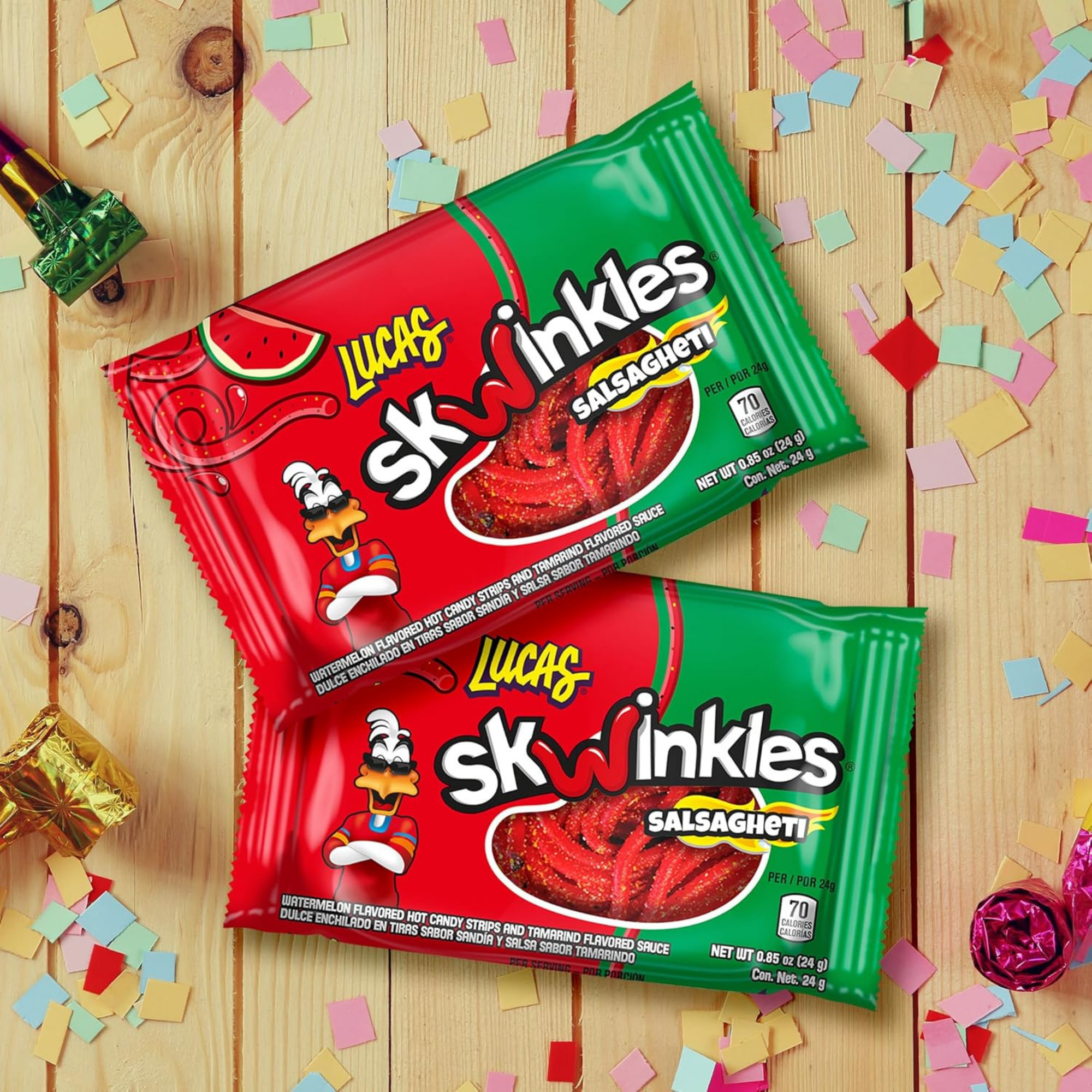Two Lucas Skwinkles Salsagheti candy packs on a wooden surface, surrounded by colorful confetti and wrapped candies, create a festive vibe.