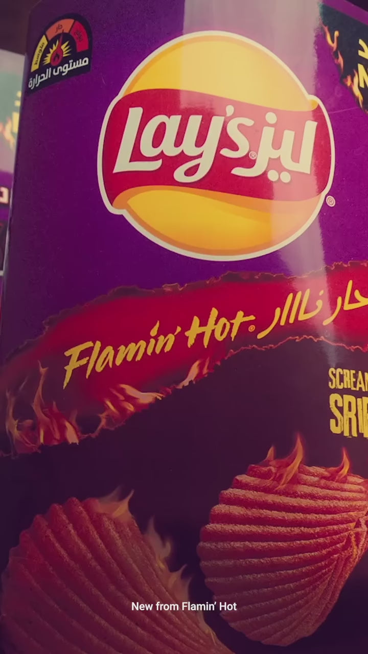 Screamin’ Sriracha snack lineup from Saudi Arabia featuring Lay’s, Doritos, and Cheetos with Flamin’ Hot sriracha flavors in bold purple packaging