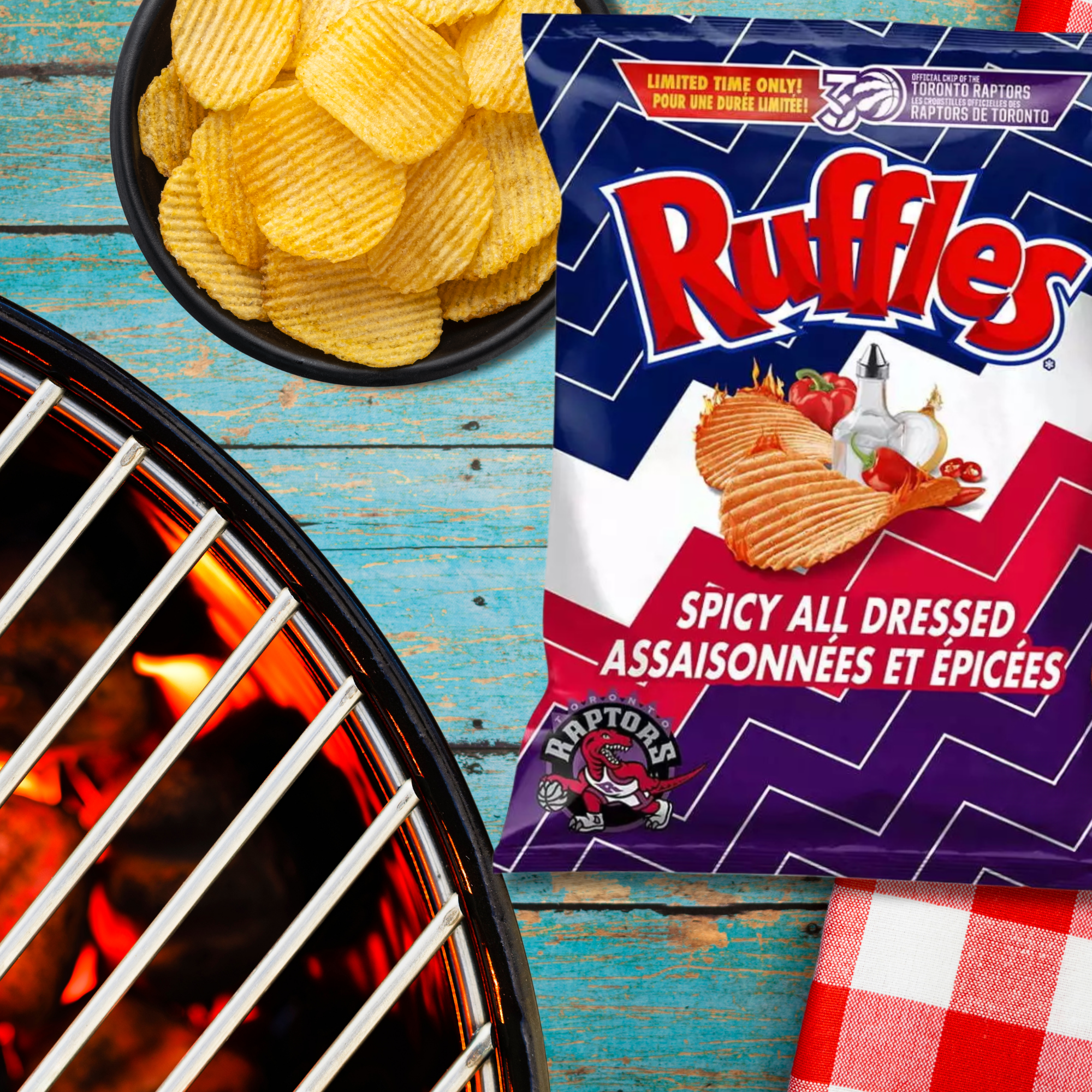 Ruffles Spicy All Dressed potato chips bag with a bowl of chips and grill in the background.